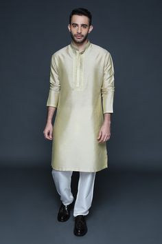 Gold beige cotton silk kurta with mandarin collar, full sleeves and geometric pattern resham thread embroidered placket. Paired with pants.
Component: 2
Pattern: Embroidered
Type Of Work: Resham Thread Work
Neckline: Mandarin Collar
Sleeve Type: Full Sleeves
Fabric: Cotton Silk
Color: Gold,Beige
Other Details: 
Front concealed placket
Side slits on kurta
Occasion: Mehendi and Puja,Sangeet - Aza Fashions Kurta Set For Men, Silk Kurta, Thread Work, Kurta Set, Full Sleeves, Embroidered Silk, Mandarin Collar, Cotton Silk, Aza Fashion