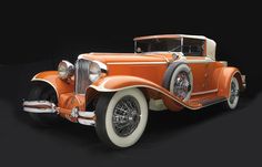 an orange and white vintage car on a black background