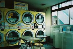 a room that has several washers and dryers on the wall in front of it