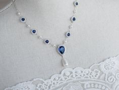 Blue Sapphire Necklace, Bridal Pearl/Sapphire CZ Necklace, Something Blue Necklace, Wedding Jewelry, Bridal Jewelry, Sapphire Pearl Necklace Materials: - 9mm rhodium plated blue sapphire and white cubic zirconia connectors  - rhodium plated over brass chain - white/Ivory Cream Swarovski pearls - 15x24mm Blue Sapphire cubic zirconia teardrop pendant The listing is for one necklace.  ❤❤ ❤BRIDAL and BULK ORDERS DISCOUNT ❤ ❤❤  5% Discount : 2 items (Use Coupon Code - 5DISCOFF) 10% Discount : 3-5 items (Use Coupon Code - 10DISCOFF) 15% Discount : 6 items and more (Use Coupon Code - 15DISCOFF) Here is a helpful link how to use the coupon code discount: www.etsy.com/help/article/350 The necklace will arrive packaged ready for gift giving in a delicate white jewelry box with a silver ribbon. Match Sapphire Necklace Wedding, Unique Wedding Jewelry, Blue Wedding Jewelry, Jewelry Sapphire, Blue Sapphire Necklace, Bridal Pearl Necklace, Pearl Necklace Vintage, Pearl Necklace Wedding, Pearl Jewelry Wedding