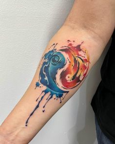 a person with a colorful tattoo on their arm and the colors are blue, red, yellow and orange