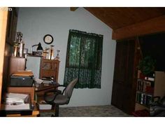 a room with a desk, chair and bookshelf