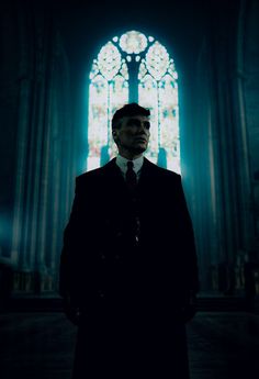 a man standing in front of a stained glass window