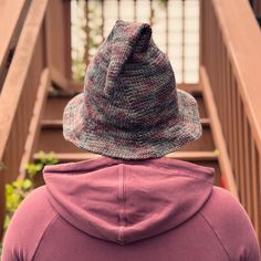 a person with a hat on their head looking down at stairs in the back ground