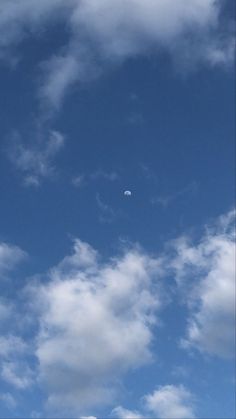 an airplane is flying through the blue sky with white clouds in the foreground,