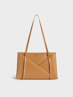 This product is made with at least 20% sustainable materials by weight. CHARLES & KEITH uses recycled, degradable, organic, and water-based materials in our eco-conscious collection. Immediately eye-catching, this Midori tote is a head-turner. The classic rectangular tote silhouette has been elevated with tasteful details -- geometric folds draw the eye to the luxurious camel finish, which is perfectly complemented by sculptural knots on the bag straps. Effortlessly elegant, the minimal design feature clean, flowing lines. Boasting a roomy interior, it will hold all that you need for the day and more. Complete with a detachable and adjustable strap for a hands-free option, this polished carrier strikes a balance between maximum function and visually appealing form. Black Saddle Bag, Minimal Bags, Chic Crossbody Bag, Stylish Purse, Classic Handbags, Luxury Bag, Charles Keith, Zip Wallet, Everyday Bag