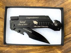 a knife in a black box with the name and date engraved on it's blade