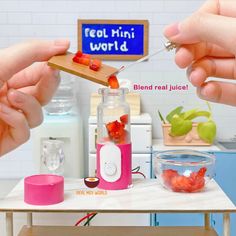 two hands are using a blender to make strawberries in a jar with the words real mini world on it