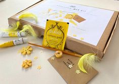 the contents of a craft kit are laid out on a table with yellow feathers and other items