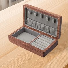 an open wooden box with compartments on top of a table