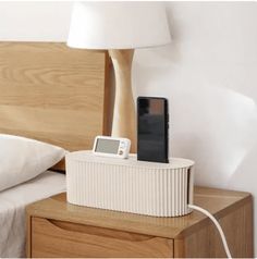 a cell phone is plugged into a charging station on a nightstand