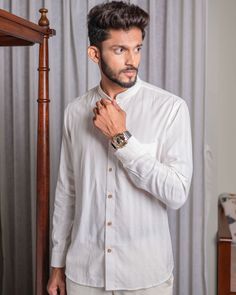 This shirt is a classic white button-down with a twist. It has wooden buttons that add some natural charm and contrast to the crisp white fabric. The shirt also has a pocket on the left side for convenience and style. The shirt is made of cotton that is soft and comfortable to wear. The shirt can be paired with any pants or jeans, and accessorized with a watch or a tie. This shirt is a versatile and elegant choice for any occasion. White Cotton Dress Shirt With Button Cuffs, White Collared Dress Shirt With Buttons, White Linen Shirt With Buttons, White Button Down Shirt, Button Down, White Button Down, Wooden Buttons, Style Expert, White Fabric