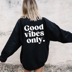 When you throw on this sweatshirt, you'll be letting everyone know that their negative vibes are not welcome! Made in 4 different colors, this pullover sweatshirt design is ultra-cozy for either staying in or going out into those winter nights. Thanks to its large graphic font that reads, "Good Vibes Only," this crew neck sweatshirt is the right amount of positivity you need to start the day. SWEATSHIRT MATERIAL: - 50% Cotton / 50% Polyester  SHIPPING: - All items will be processed within 1-3 business days after ordering - After we ship your order shipping time is based on your shipping choosing CARE INSTRUCTIONS: - Inside out, wash with delicate cycle. - Lay flat to dry - Do not bleach - Do not iron directly onto the design - Do not dry clean. Relaxed Fit Slogan Hoodie For Loungewear, Long Sleeve Sweatshirt With Text Print For Loungewear, Long Sleeve Text Print Sweatshirt For Loungewear, Trendy Black Sweatshirt For Loungewear, Trendy Relaxed Fit Sweater With Letter Print, Oversized Comfortable Sweatshirt With Graphic Print, Trendy Crew Sweatshirt For Loungewear, Trendy Crew Neck Sweatshirt With Letter Print, Oversized Slogan Sweater For Loungewear