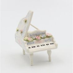 a miniature white piano with flowers on it