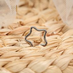 a silver ring sitting on top of a woven basket