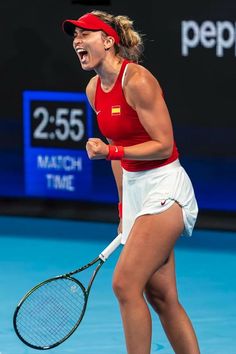 a woman holding a tennis racquet on top of a tennis court with her mouth open