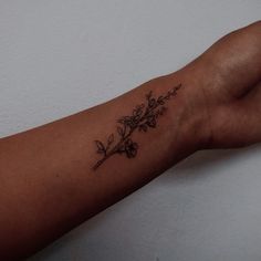 a woman's arm with a flower tattoo on it