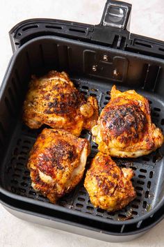 four pieces of chicken in a black air fryer