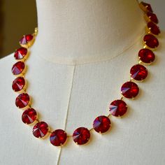 Delight in the luxurious shade of Scarlet red featured in this statement necklace. Opportunities will abound to show off this stunner. The rich ruby red color can be worn throughout many seasons and is sure to upgrade any outfit .  Description: 18 crystals 16mm Rivoli cut Color: Light Siam  Set in: Shiny Gold Extender chain and lobster claw clasp:  18K Gold plated Length: Shortest: 14.75 inches Longest: 19.5 inches *You are welcome to contact me for a change in length. **All necklace settings are made of brass which have been plated in each particular color and finish. (Rhodium, Silver, Gold, Bronze, etc) Care: The luminous and reflective quality of your necklaces will be maintained when simple care practices are observed: Take care and do not spray any type of liquid onto necklace such as Glamorous Red Crystal Necklaces, Red Ruby Choker Necklace, Red Ruby Choker Jewelry, Luxury Red Crystal Necklace, Red Ruby Necklace For Evening, Red Choker Necklace For Formal Occasions, Red Choker Necklaces For Formal Occasions, Elegant Red Choker For Formal Occasions, Formal Red Choker Necklaces