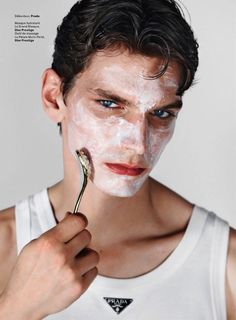 a man is holding a toothbrush in front of his face while shaving it