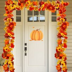 a front door decorated with fall leaves and pumpkins