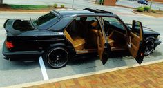 a black suv with its doors open parked in a parking lot next to a curb