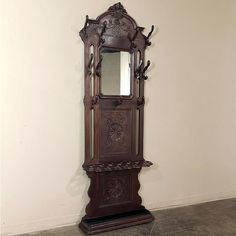 an ornate wooden grandfather clock on display in a room with white walls and tile flooring