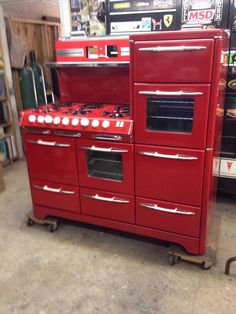 an old fashioned red stove and oven in a shop