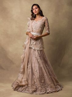 This set features a champagne gold pearl-embellished peplum & raw silk lehnga embroidered dupatta with organza ruffles. Neck: Sweetheart Neck Sleeve Type: Half Sleeves Fabric: Organza; Net; Raw... Beige Bollywood Sets With Pearl Embroidery, Embellished Beige Anarkali Sets, Beige Embellished Anarkali Sets, Anarkali Style Organza Sets With Ruffles, Diwali Pearl Embroidery Organza Sets, Champagne Festive Dress, Festive Champagne Dresses, Wedding Lehenga With Ruffles In Organza, Elegant Festive Anarkali Set With Ruffles