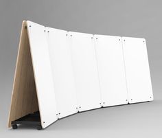 a white board with four pieces of wood attached to the back of it, sitting on top of a gray surface