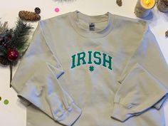 This is a sweat shirt with an embroidered design of Irish in green on it. Available in sizes small to X-Large sweatshirts. Colors available are sand, pink, sport grey, heathered red, and heathered maroon. We have a wide range of other images available, along with other colored shirts. Please send us a massage to inquire about the other options. These items are machine embroidered. They  are made in Amarillo,Tx. Because they are done individually there may be slight variations to the items. Casual Sweatshirt With Embroidered Graphics, Casual Green Sweater With Embroidered Graphics, Casual Heather Fleece Sweatshirt, Casual Hoodie With Embroidered Graphics And Crew Neck, Casual Crew Neck Hoodie With Embroidered Graphics, Casual T-shirt With Embroidered Logo For Winter, Casual Winter T-shirt With Embroidered Logo, Green Collegiate Crew Neck Hoodie, Green Collegiate Hoodie With Crew Neck