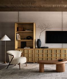 a living room filled with furniture and a flat screen tv mounted on a wall above it