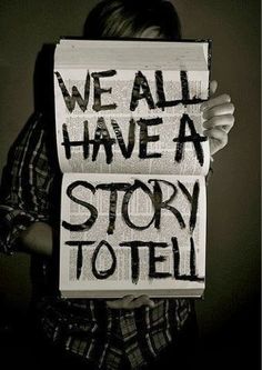 two people holding up signs that say we all have a story to tell