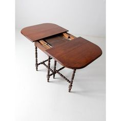 a small wooden table with two drawers on it's legs and an open drawer in the middle