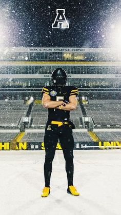 a football player standing in the snow with his arms crossed