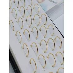 several pairs of gold hoop earrings are displayed in a display case on a white surface