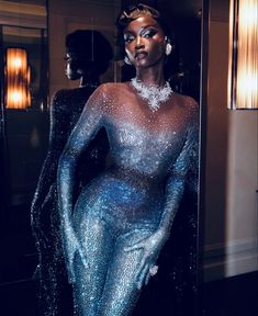 a mannequin is dressed in blue and silver glitter, with her hands on her hips