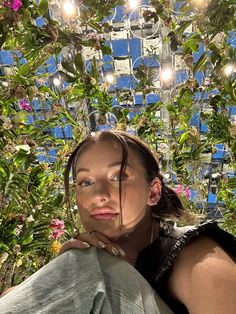 a woman is sitting in front of some plants