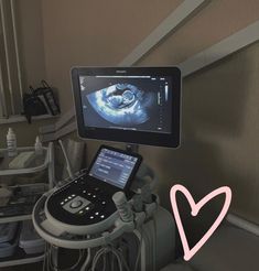 a hospital room with a monitor and medical equipment in front of the monitor is a heart - shaped symbol