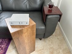 a table with a book on it next to a couch and coffee cup in the corner