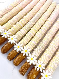 there are many donuts with white flowers on the top and one has yellow centers