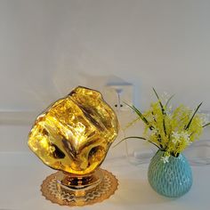 two vases with flowers in them sitting next to each other on a white table