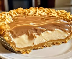 a piece of pie on a white plate with chocolate frosting and pretzel crumbs