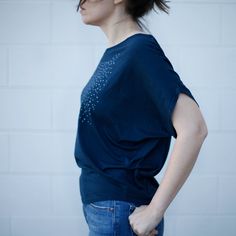 Our original Meteor Shower design has been hand-printed in pale gray water-based ink onto deep navy blue dolman sleeve tops. These shirts have a wide neckline and can be worn off the shoulder. They have a feminine, dramatic drape that tapers down to a fitted hip. FIT & SIZING: - Available in sizes S-2XL - Intended to drape loosely throughout chest and upper body - Tailored for a *SNUG FIT* in the hips - Model shown is 5'8 and a size 6. She's wearing a large. GARMENT DETAILS & CARE INSTRU Organic Cotton Short Sleeve Conscious Top, Organic Cotton Relaxed Fit Tops For Loungewear, Relaxed Fit Organic Cotton Tops For Loungewear, Indigo Relaxed Fit Top For Summer, Everyday Blue Organic Cotton Top, Blue Relaxed Fit Organic Cotton Tops, Relaxed Fit Blue Organic Cotton Tops, Indigo Tops For Everyday Spring Wear, Indigo Crew Neck Tops For Summer