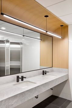 a public restroom with two sinks and mirrors