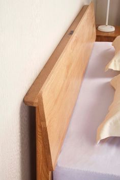 a bed with a wooden headboard next to a white wall