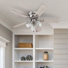 a ceiling fan is mounted on top of a bookshelf