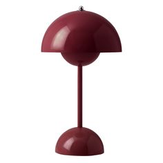 a red table lamp sitting on top of a white floor