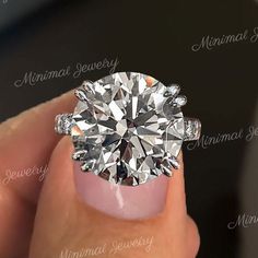 a woman's hand holding a ring with a diamond in the center and two diamonds on