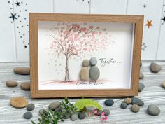 two pebbles sitting under a tree with the words together